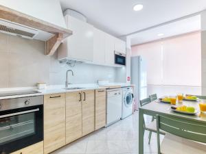 a kitchen with white appliances and a counter with a table at Vita Portucale ! Almada Trendy Retreat in Almada +32 photos