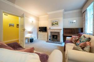 a living room with two couches and a fireplace at Hacheston Lodge in Marlesford