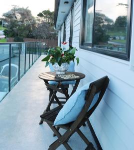 une table de patio avec un coussin bleu sur un porche dans l'établissement Blanc Suites Collection, à Silverdale 6 autres photos