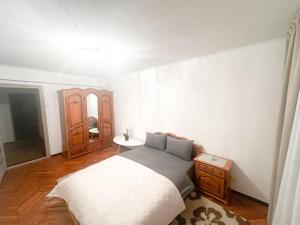 a bedroom with a bed and a wooden floor at Central Best 2 bedrooms in Chişinău