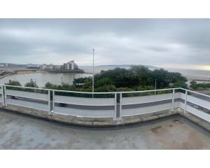 a balcony with a white railing next to a body of water at Savoy Hotel in Weston-super-Mare