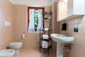 Un baño con lavabo, inodoro y ventana. en Ride Home 2, en Commezzadura