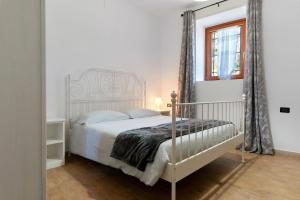 a bedroom with a white bed and a window at Ride Home 2 in Commezzadura +8 photos