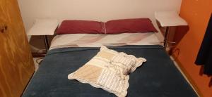 a bed with two pillows on top of it at Apartamento in Olavarría