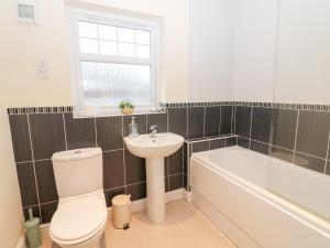 a bathroom with a toilet and a sink and a bath tub at Lingla House in Frizington +22 photos