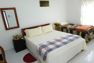 a small bedroom with a bed and a mirror at Tropical Suites - Airport Transit Residence in Negombo