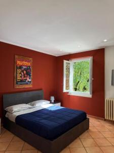 a bedroom with a blue bed in a red wall at Double Spaces Apartaments in Tortona