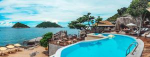 a pool at a resort with a view of the water at Dusit Buncha Koh Tao by Riya Group in Ko Tao