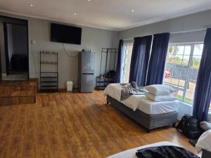 a living room with two beds and a flat screen tv at Da Vinci Palms in eMalahleni