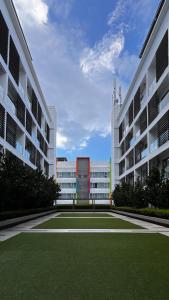 a large building with a grass field in front of it at The Welcoming Nest, Aeropod in Kota Kinabalu