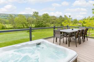 a hot tub on a deck with a table and chairs at Landal Aysgarth in Aysgarth