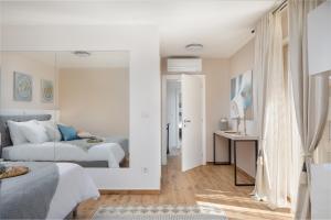 a white bedroom with two beds and a mirror at Luxury Villa San heated pool sauna in Sveti Filip i Jakov +43 photos