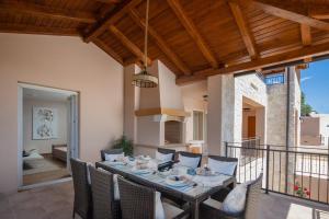 a dining room with a table and chairs on a balcony at Luxury Villa San heated pool sauna in Sveti Filip i Jakov