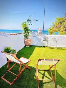 Un césped con dos sillas y una mesa. en Casa Bali, en Benajarafe