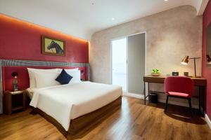 a bedroom with a white bed and a desk and a red wall at Kin Hotel Onsen Edition in Ho Chi Minh City +36 photos