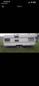 a white bus parked on the grass in a field at Camping Kosovo Treehouse campground of anykind in Ferizaj