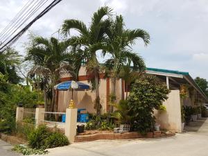 ein Haus mit Palmen davor in der Unterkunft The Star Villa Resort in Hat Yai