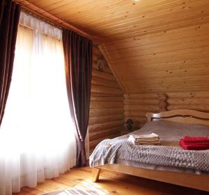 a bedroom with a bed in a log cabin at Садиба Марія in Polyana