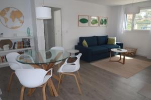 un soggiorno con tavolo in vetro e sedie bianche di RESIDENCIAL PLAYA CABRIA ad Almuñécar