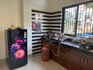 a kitchen with a refrigerator and a vase with flowers at Lir-etso Homestay in Diphu