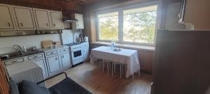 a kitchen with a table with a white table cloth at Hostel 4 in Šiauliai +4 photos