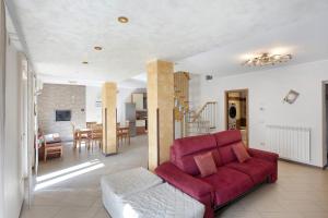 Una sala de estar con un sofá rojo y un comedor. en Villetta Relax, en Ruviano