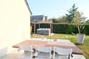 eine Terrasse mit einem Tisch, Stühlen und einem Grill in der Unterkunft Minimaliste Oasis - Golf & Spa in Saint Lo