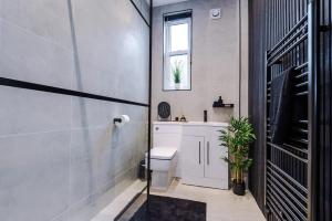 a bathroom with a toilet and a sink and a window at Luxury 3Bed Apartment York Centre Sleeps 6 in York