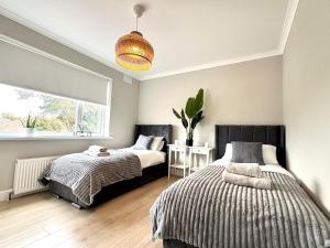 Un dormitorio con dos camas y una ventana en Kendal By The Coast - Cosy home in great location, en Blackpool
