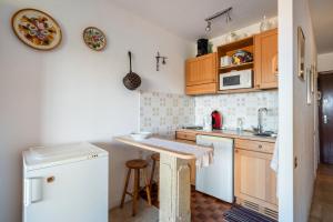 une cuisine avec des armoires en bois et un comptoir dans l'établissement Pretty Flat in the Sun, à Mandelieu-la-Napoule