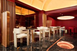 a dining room with white chairs and a table at Kin Hotel Onsen Edition in Ho Chi Minh City