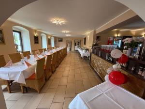a dining room with white tables and chairs in a restaurant at Amara.Festsaal.Gasthaus.Pension in Mohorn