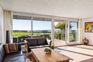 a living room with a couch and a table at Rolsø Retreat in Knebel