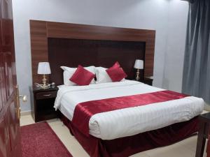 a bedroom with a large bed with red pillows at إن طيبة المدينة in Al Madinah