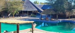 NataにあるPelican Lodge and Campingのスイミングプールと建物のあるリゾート