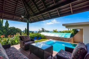 a patio with a pool and chairs and a table at Karon Beach Seaview Penthouse With Private Pool Condominium in Karon Beach