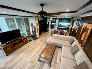 a living room with a couch and a flat screen tv at Karon Beach Seaview Penthouse With Private Pool Condominium in Karon Beach