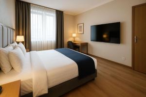 a hotel room with a bed and a flat screen tv at Gambaka Homestay in Kon Tum