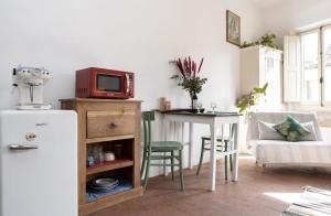 Una cocina con nevera y una mesa con microondas. en Artsy Loft, en Florencia