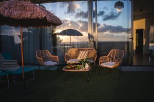 a room with chairs and a table and an umbrella at Amber Skies Seafront Retreat in El Cotillo