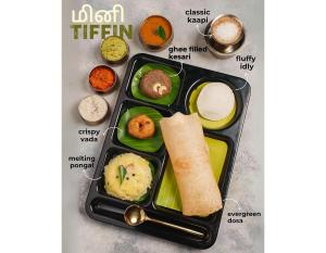 a lunch box with a tray of food on a table at Vantara Suites in Vellore