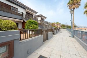una passerella di fronte a un edificio con una palma di Acaymo Sunset a Candelaria