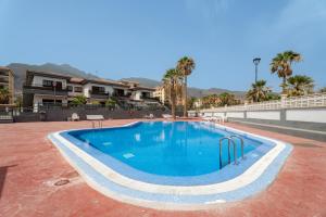 una grande piscina con palme e un edificio di Acaymo Sunset a Candelaria