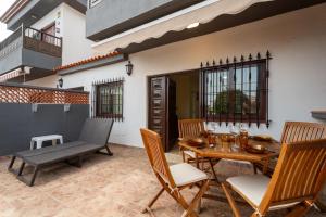 un patio con tavolo e sedie in legno di Acaymo Sunset a Candelaria