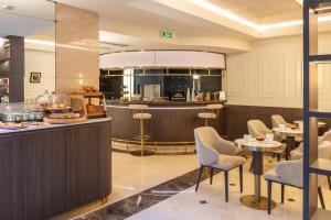 a restaurant with a bar and tables and chairs at Best Western Au Trocadéro in Paris