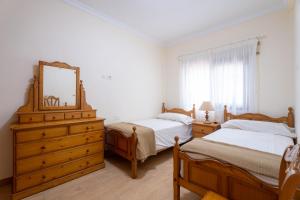 una camera con due letti, un comò e uno specchio di Acaymo Sunset a Candelaria Altre 26 foto