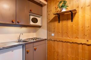 a kitchen with a sink and a microwave at Central Apartment In Heart of Val Thorens, Ski In-Out with WiFi in Val Thorens