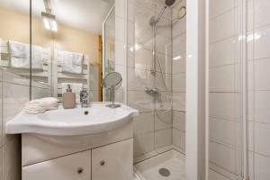a white bathroom with a sink and a shower at Central Apartment In Heart of Val Thorens, Ski In-Out with WiFi in Val Thorens