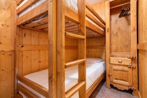 a bedroom with two bunk beds in a log cabin at Central Apartment In Heart of Val Thorens, Ski In-Out with WiFi in Val Thorens
