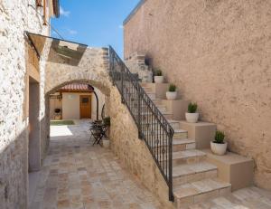 an external stairway leading up to a building with potted plants at Rustic Villa Kameni dvori heated pool in Sveti Filip i Jakov
